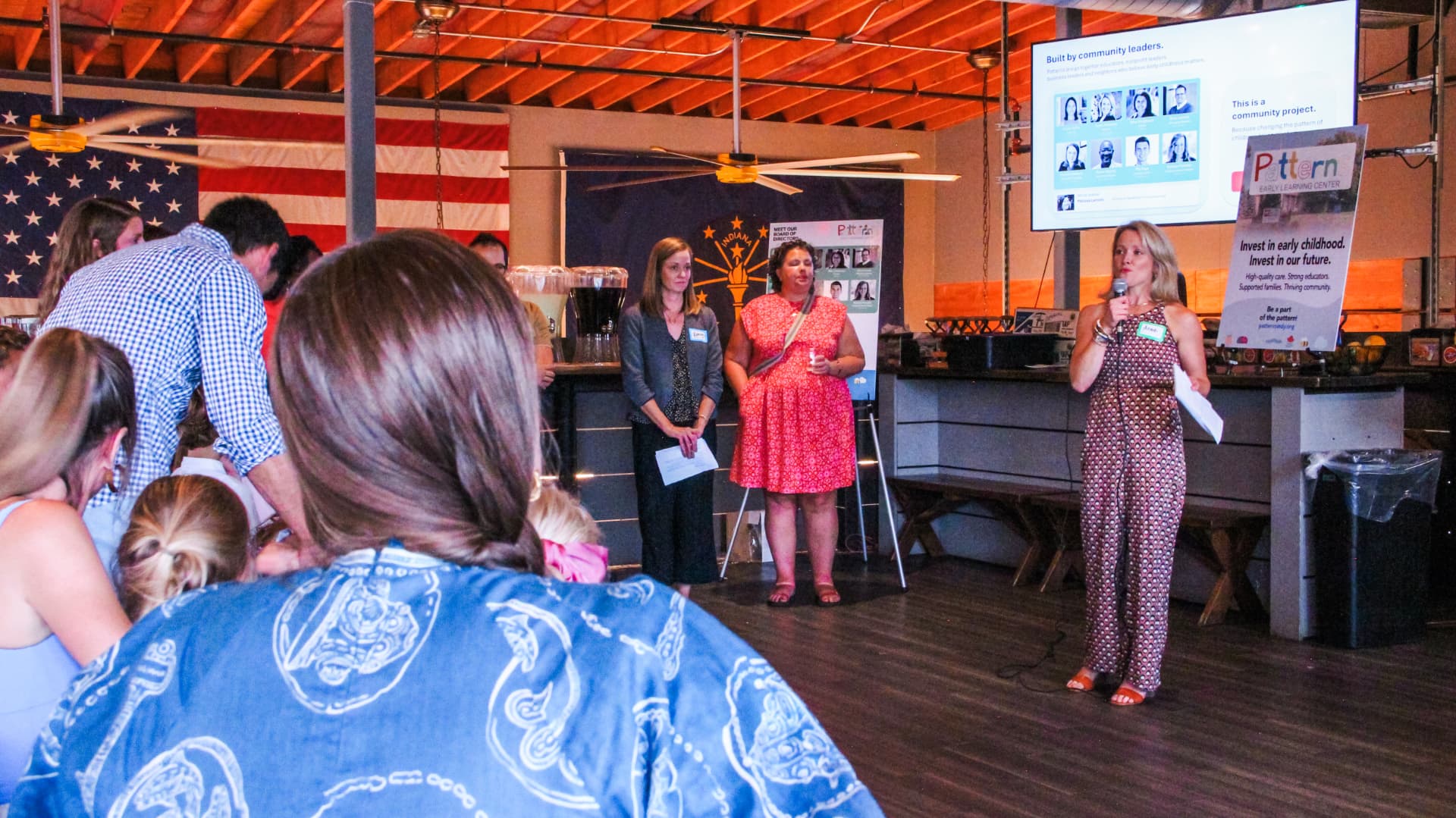 Three Patterns board members standing together while one speaks to the crowd