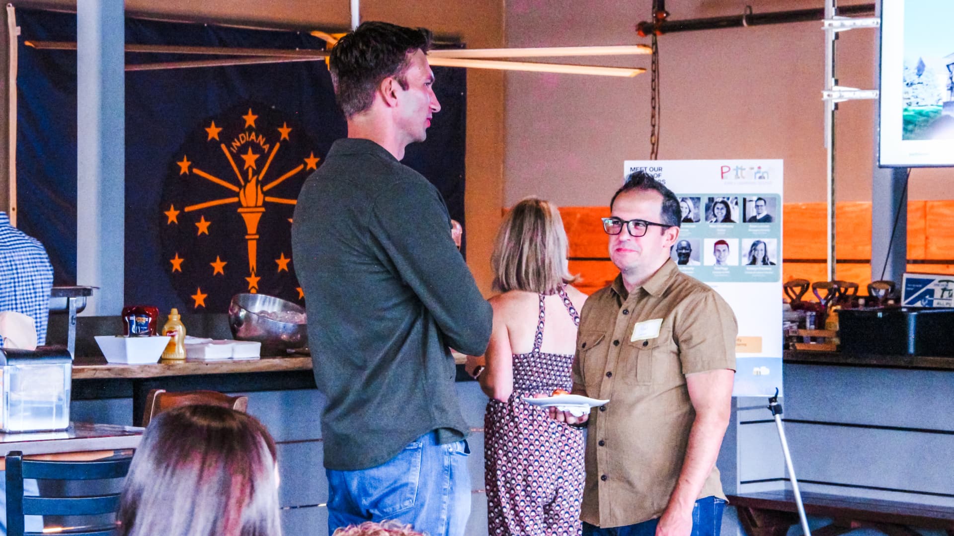 Guests talking beside the Patterns board of directors display