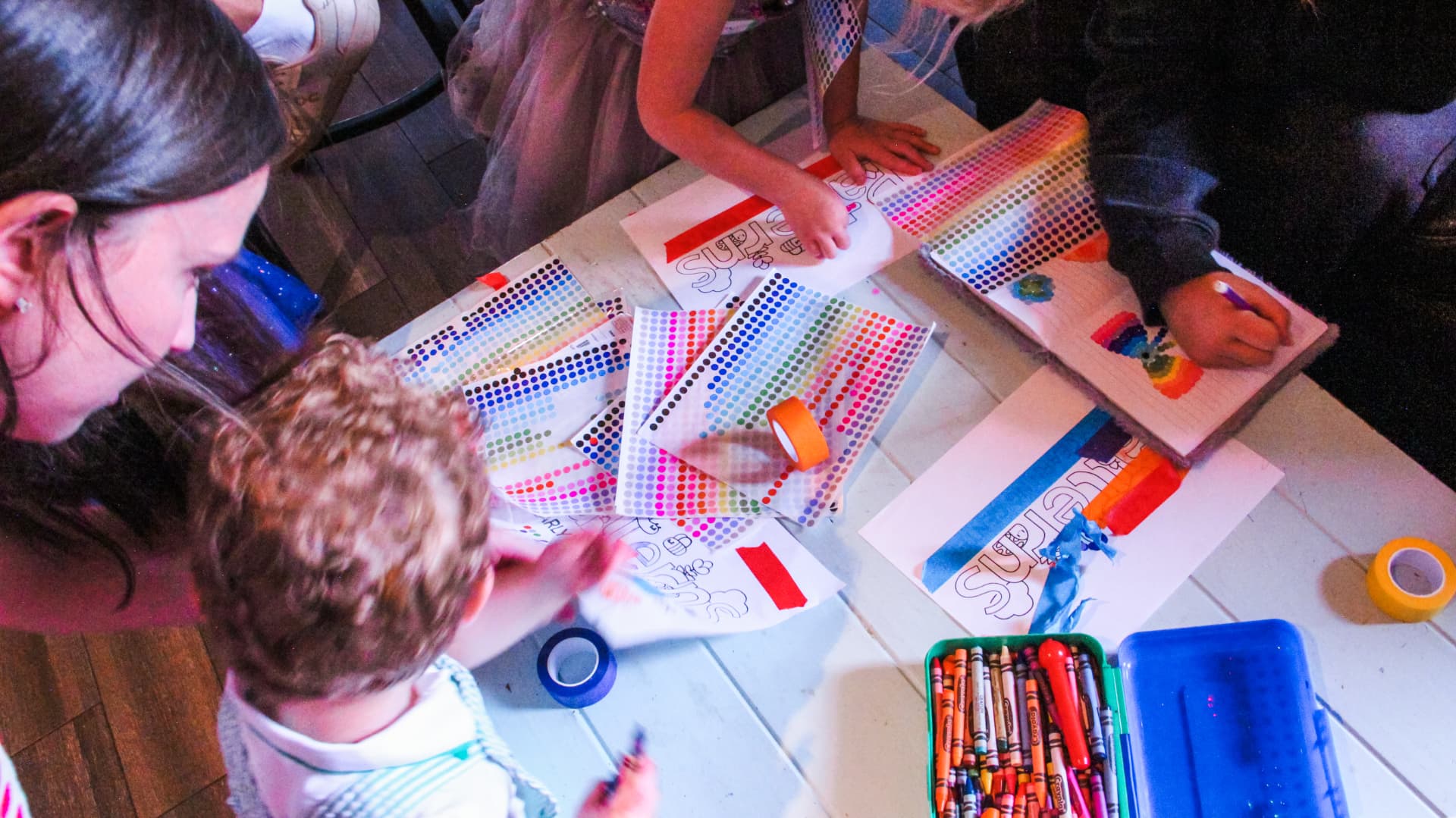 Children coloring and decorating Patterns sheets at a table